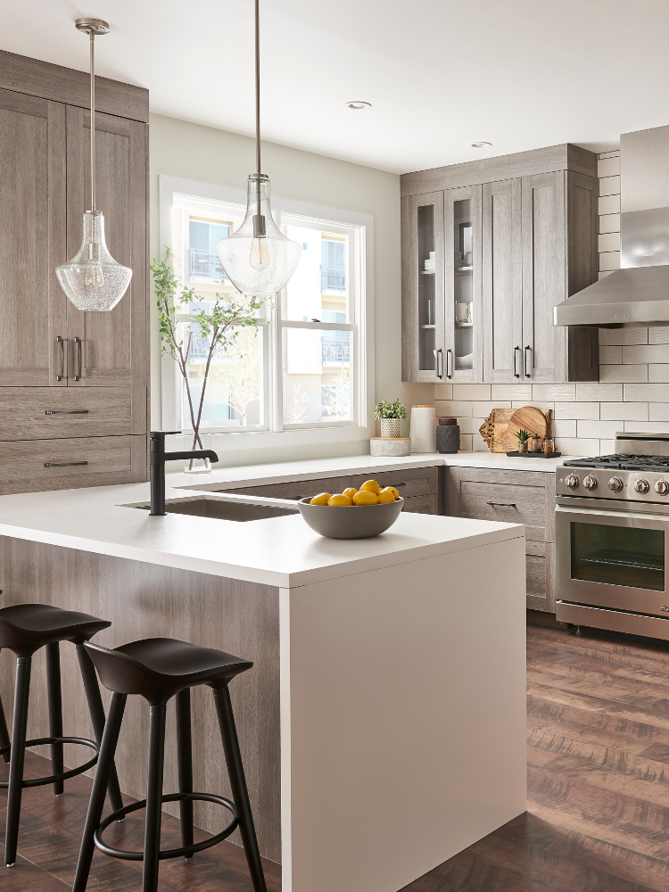 Kitchen with gray cabinetry and waterfall countertop