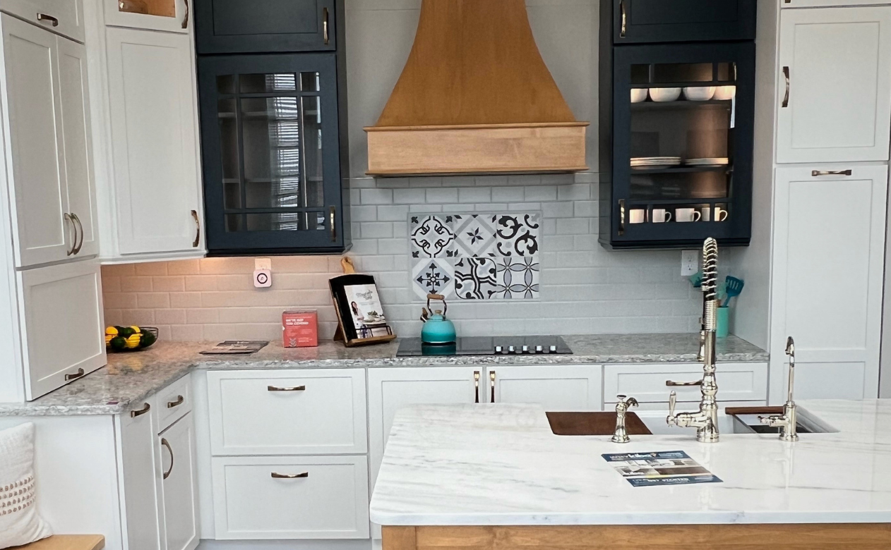 patterned tile kitchen backsplash in a kitchen with black and white cabinets