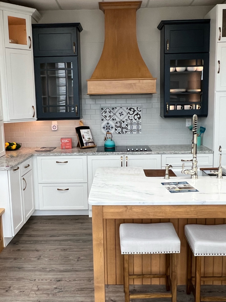 patterned tile kitchen backsplash in a kitchen with black and white cabinets