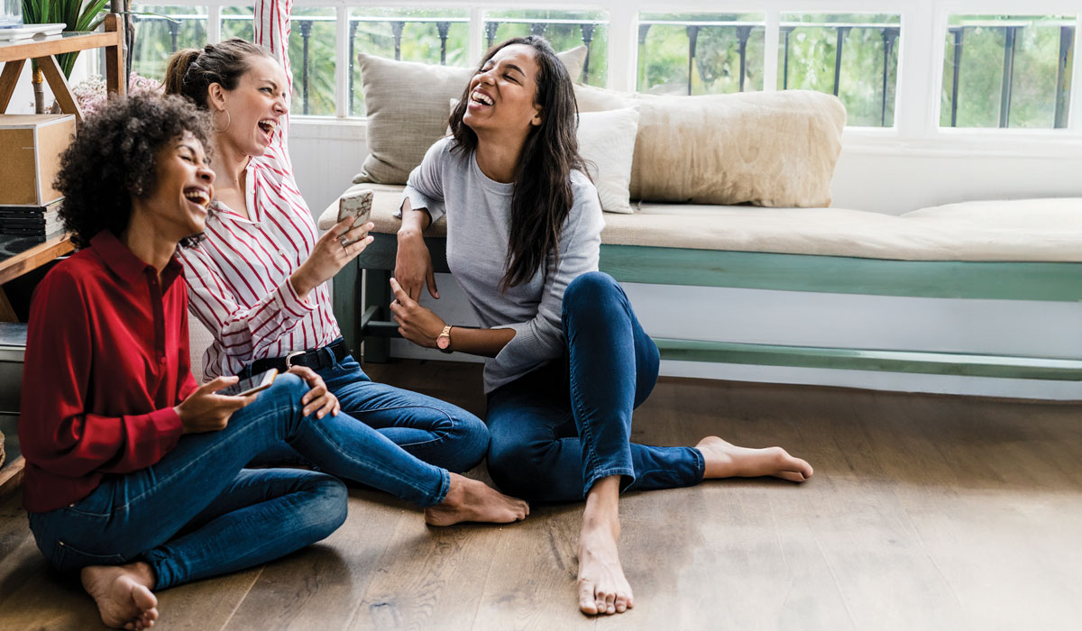 friends sitting on wood look flooring
