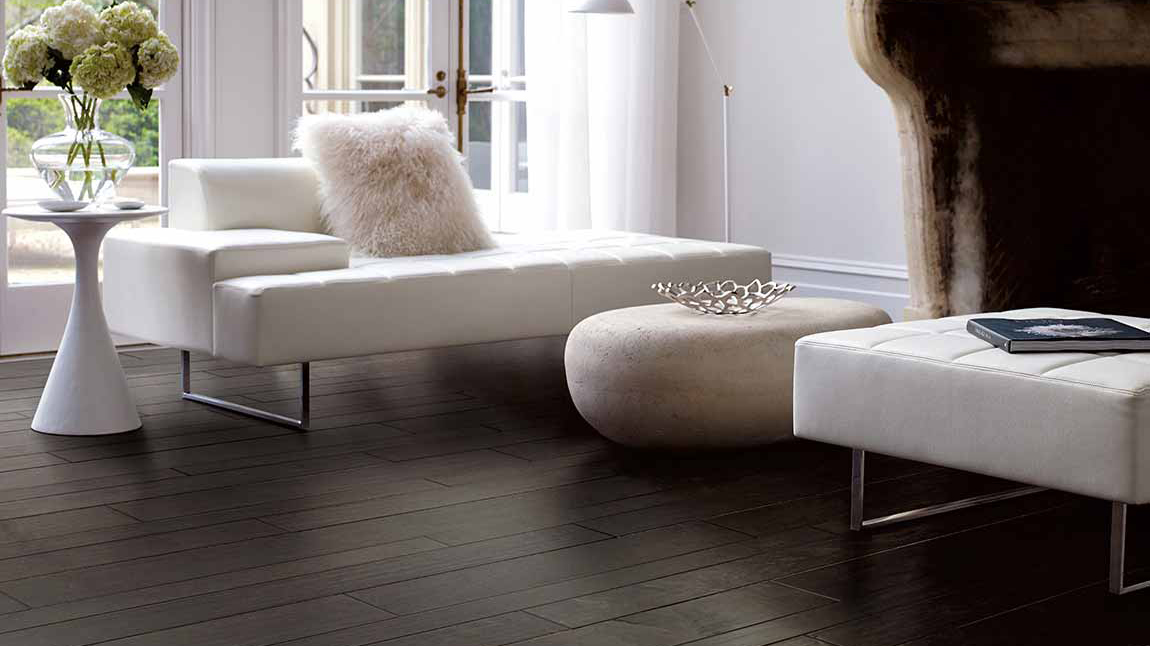 Newly installed dark hardwood flooring with white couches 