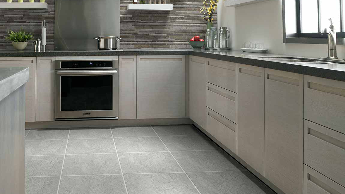 Tile flooring within a kitchen with white cabinets 