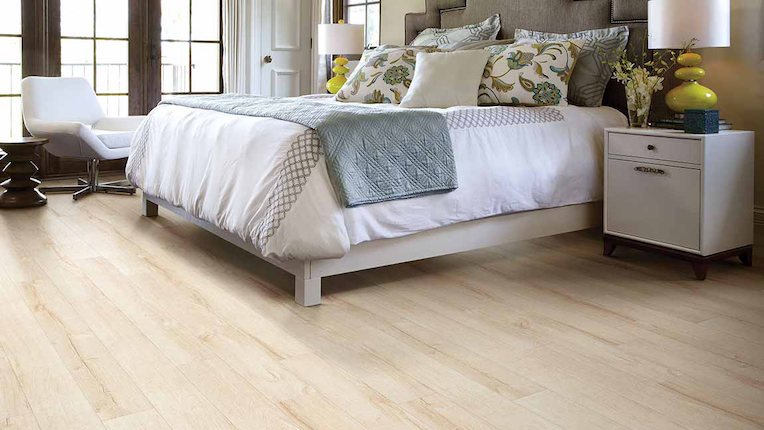 light toned wood look laminate flooring in a bright bedroom