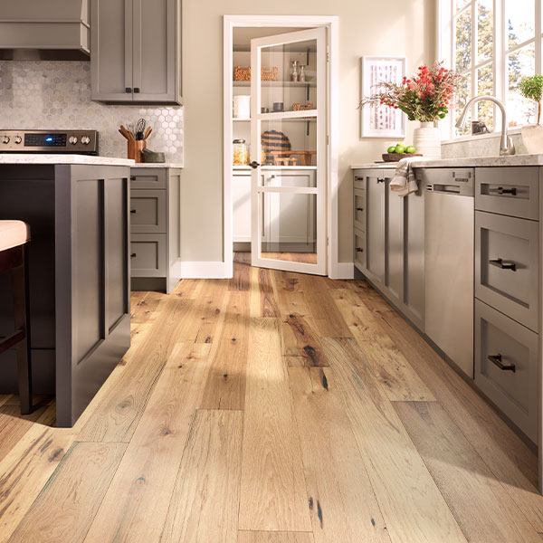 warm toned hardwood flooring in kitchen with dark cabinets